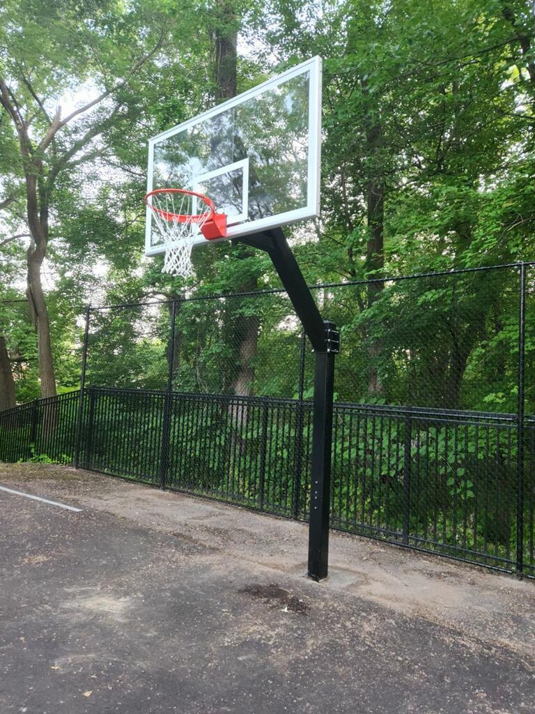 black aluminum fence with a tall chain link fence behind it