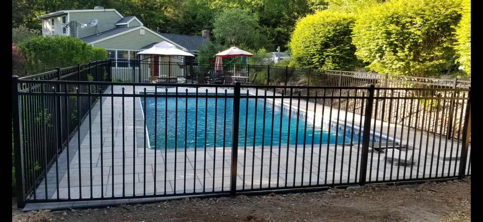 front view of a black aluminum fence around pool