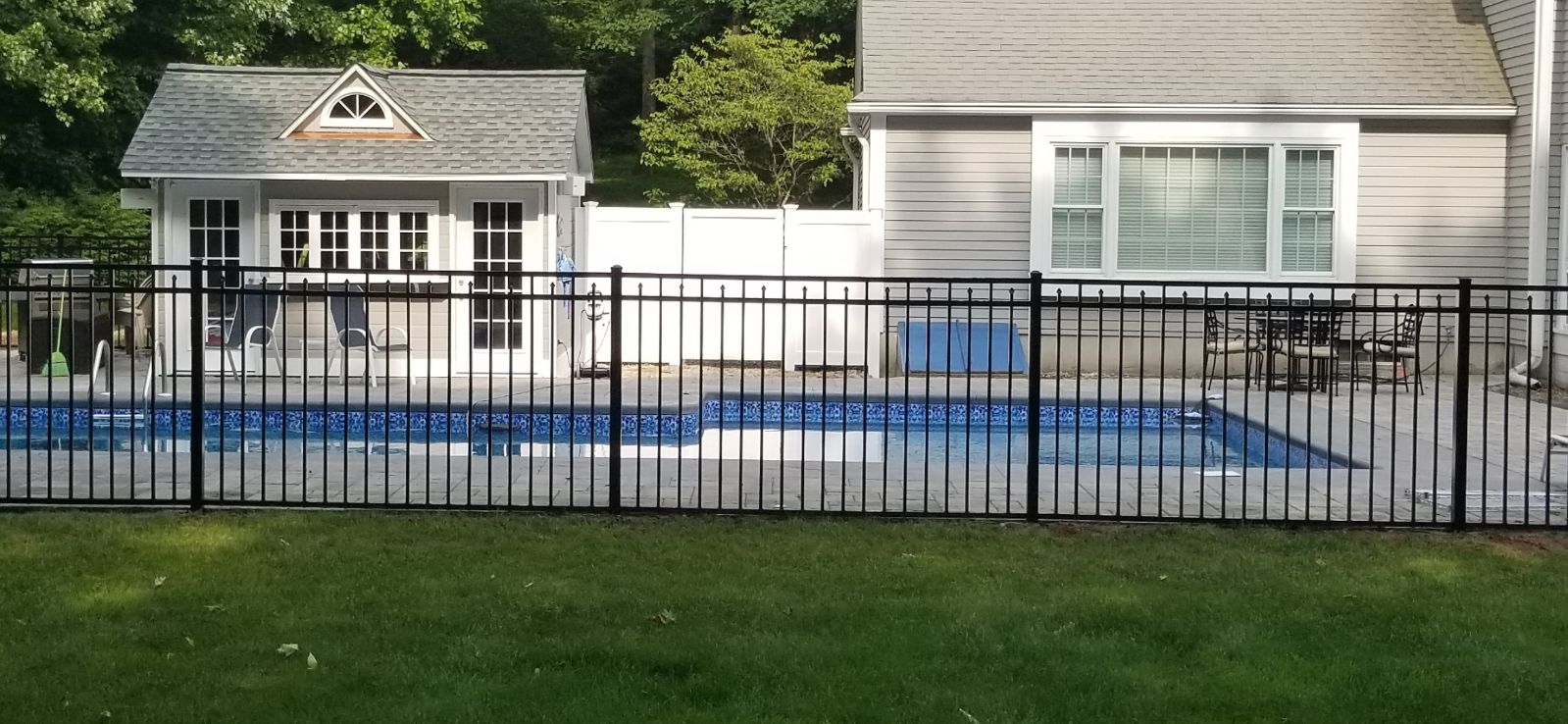 side view of a black aluminum fence around pool